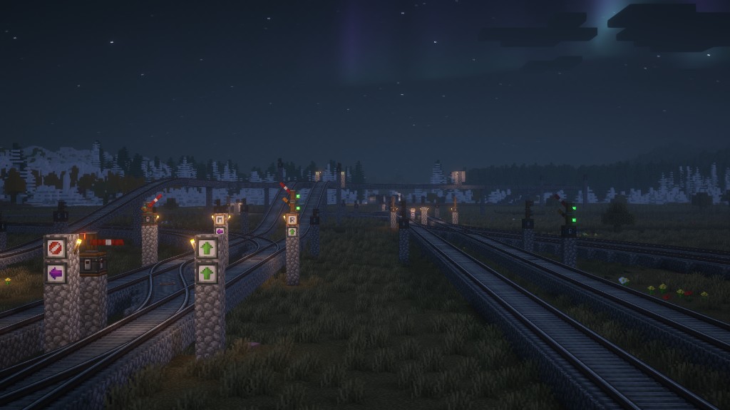 Railway junction at night with signals controlling several tracks.