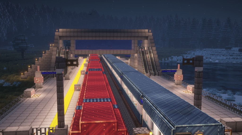 Station platform at night with two trains alongside dual platforms.