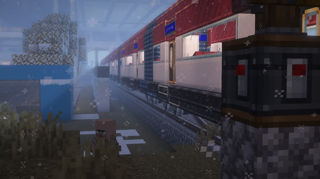 Long passenger train at a snowy Minecraft station during heavy fog and snowfall.