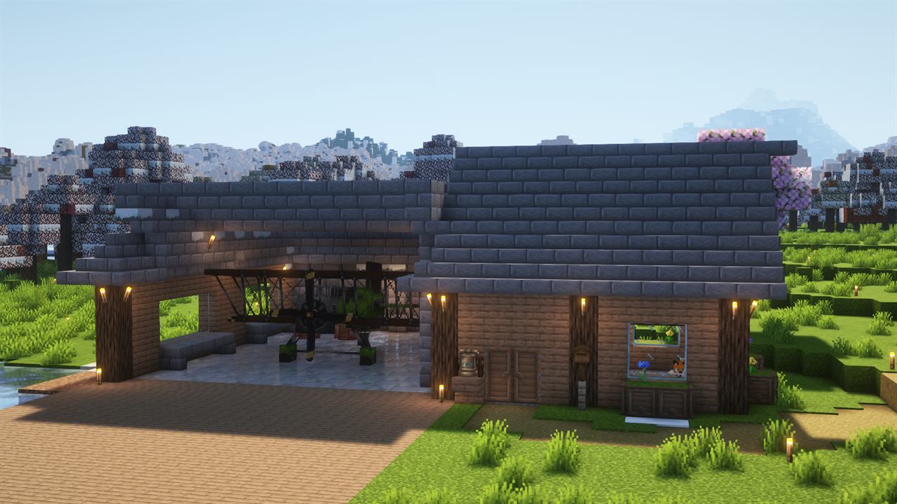 Hangar with aircraft build and snowy forest backdrop.
